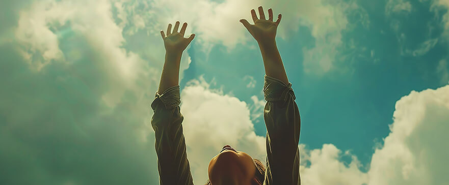 Hands to heaven, person with arms raised hands up looking at the sky