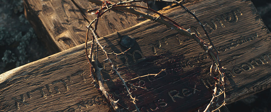 From above bloody crown of thorns placed on wooden cross with Jesus the Nazarene King of the Jews inscription after crucifixion